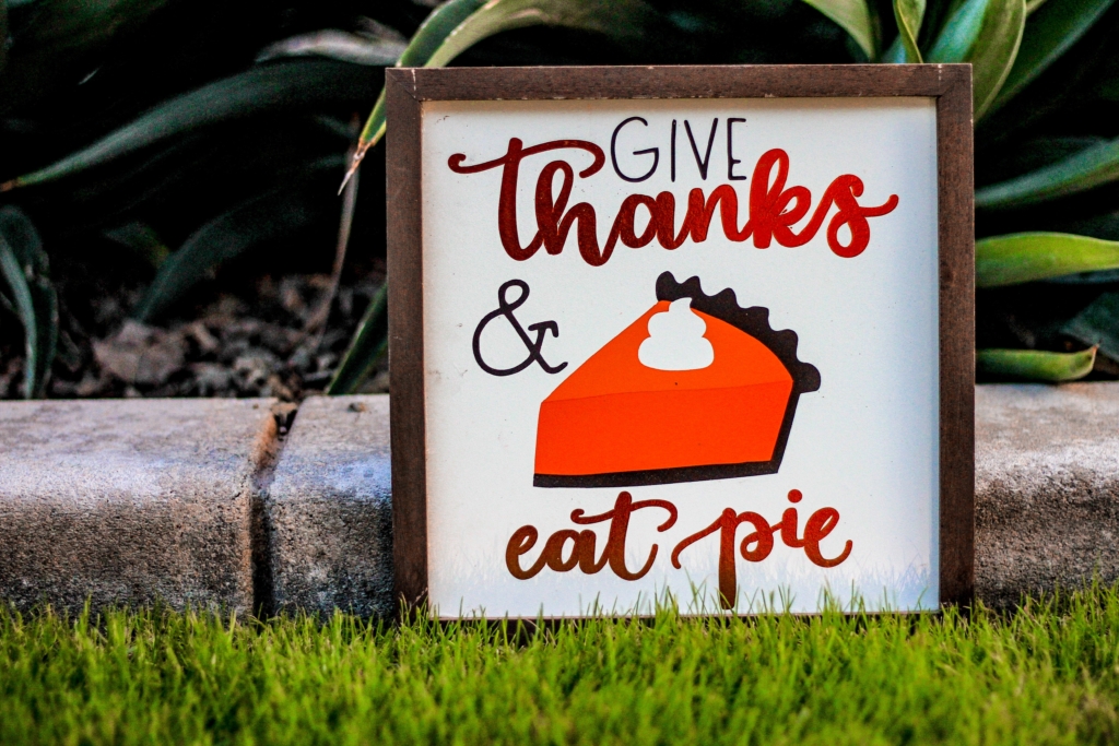 Give Thanks and Eat Pie poster with brown frame on green grass